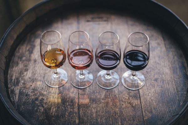 four wine glasses on a barrel