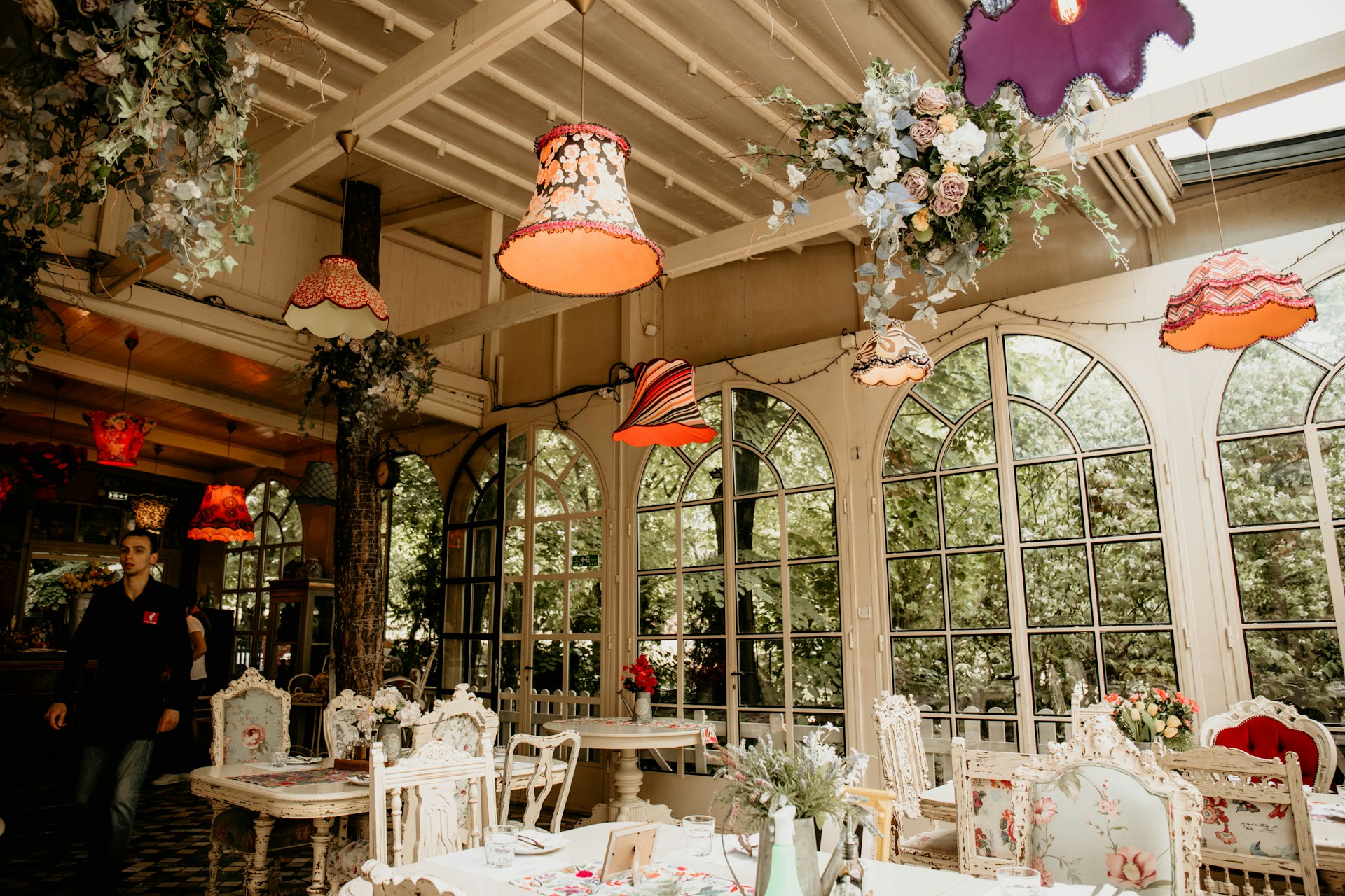 A dining area with tables, chairs, and chandeliers